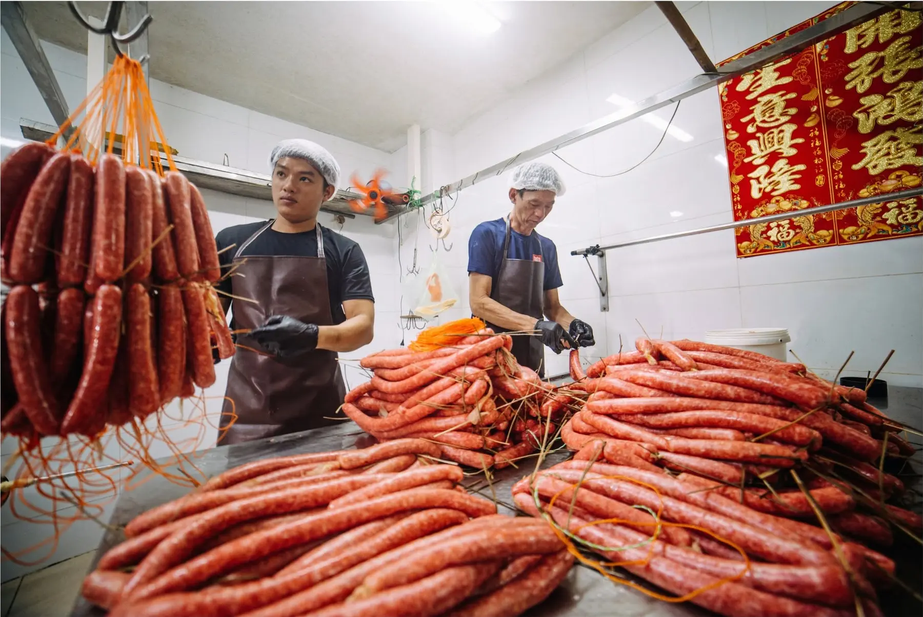 Hai thế hệ trong xưởng Thiên Hương đang hoàn thiện một mẻ lạp xưởng lớn